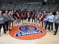 Plantilla y cuerpo técnico del Básquet Coruña posan para DXT Campeón junto al escudo del equipo en el Coliseum