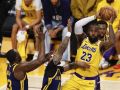 LeBron James intenta dar un pase en un partido entre Lakers y Warriors.