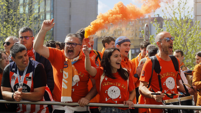 Aficionados del Básquet Coruña con botes de humo naranja durante el recibimiento al equipo el día del derbi contra el Obradoiro