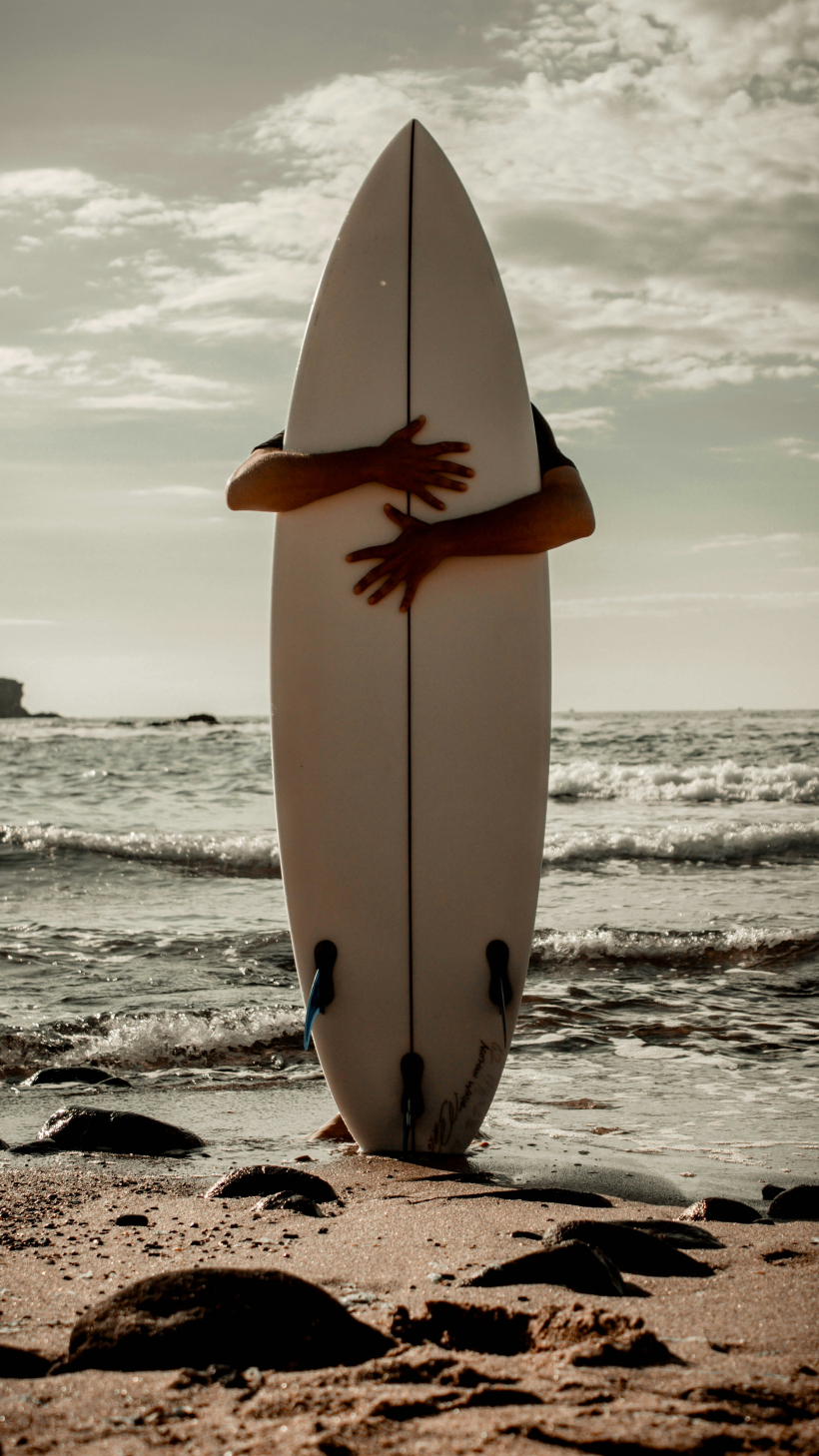 Un surfista abraza su tabla