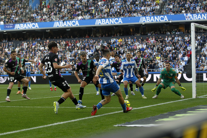 Luismi Cruz pasa a Stoichkov, con el balón ya fuera del terreno de juego, en el Deportivo-Málaga