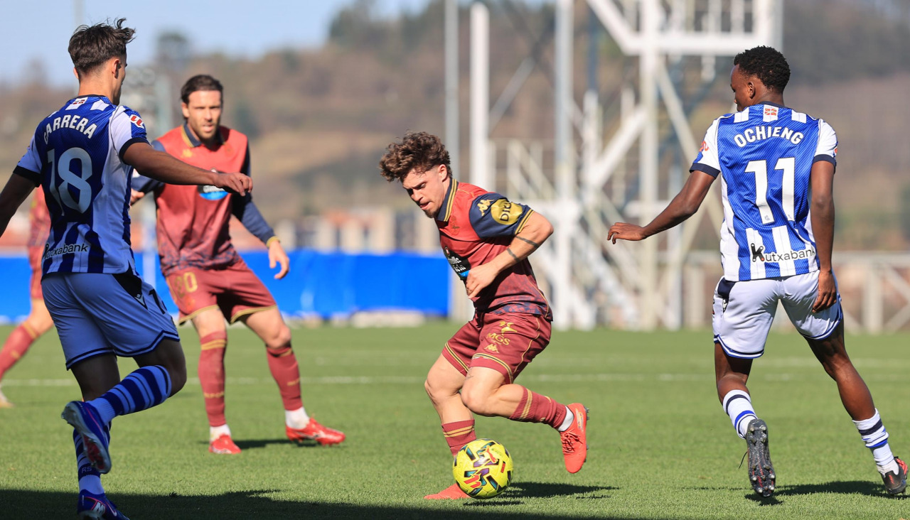 Mario Soriano controlando el balón ante futbolistas de la Real B