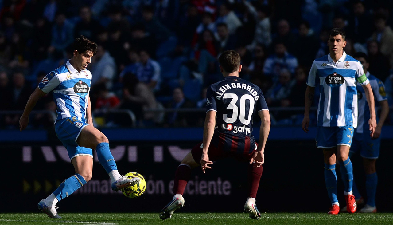 Riki Rodríguez trata de controlar el balón con Villares cerca y ante la presencia de Aleix Garrido en el Deportivo-Eibar