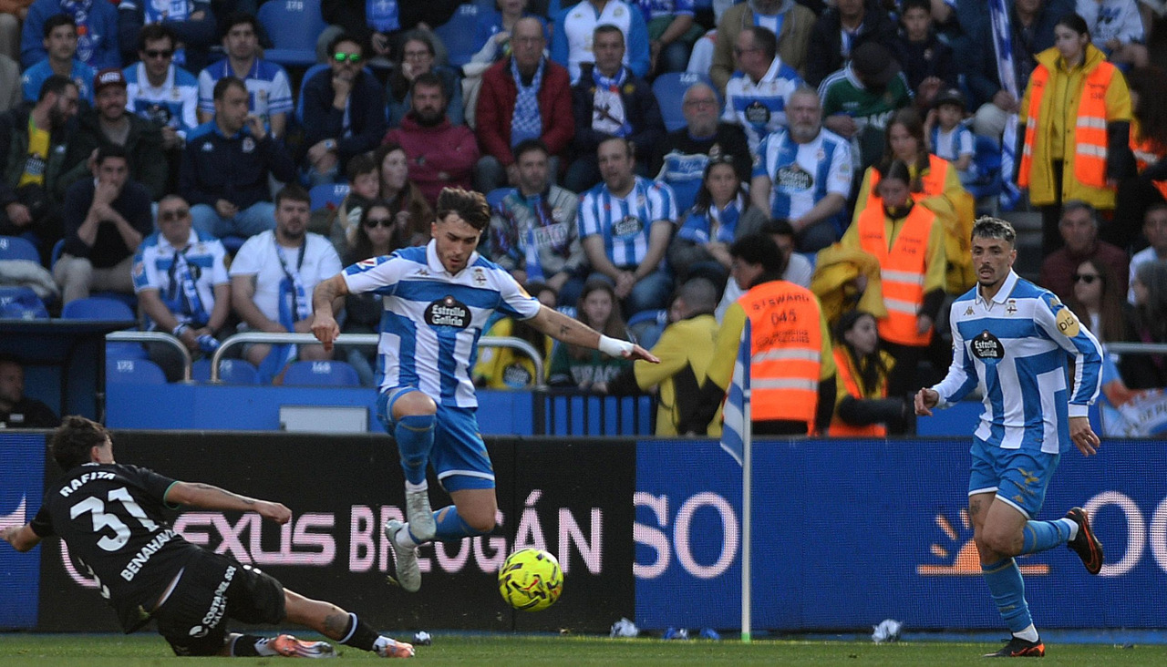 Alti disputa el balón con Rafita en el Deportivo-Málaga, con Ximo observando la acción cerca