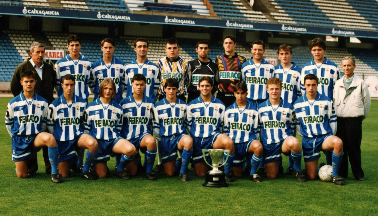 Plantilla del Deportivo campeón de España Juvenil en 1996, posando sobre el césped de Riazor con el trofeo. De pie, de izquierda a derecha: José María Blanco (entrenador), Nacho, Carlos, Pablo López, Diego Arias, Moscoso, Dani Mallo, Luis Mosquera, Araguás, Ramiro Amarelle y Julio Cagiao (delegado). Agachados: Adolfo, Roberto, Bugarín, Víctor, Juan Naya, Cedeira, Oliva, Coloma y Deus