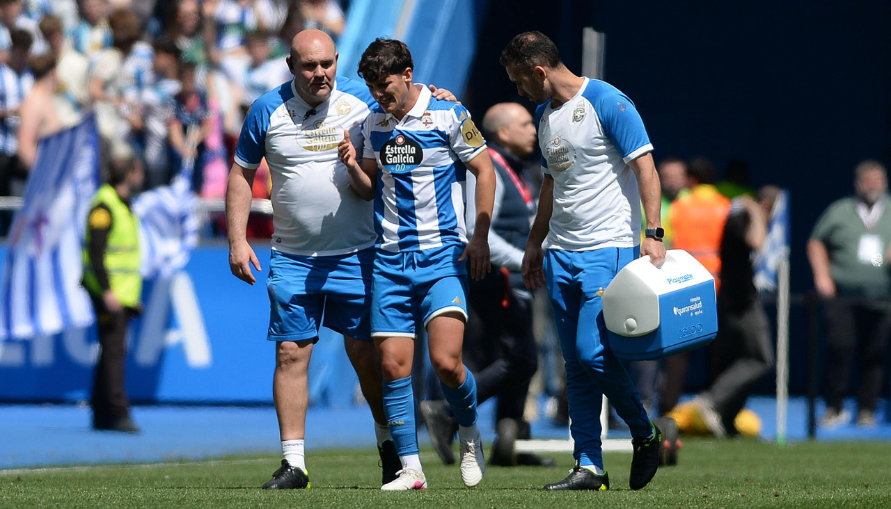 Riki Rodríguez es atendido por los servicios médicos del club tras sufrir un giro en una de sus rodillas durante el Deportivo-Andorra