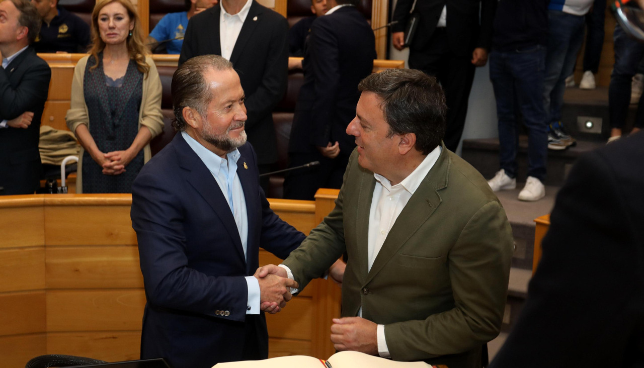Juan Carlos Escotet y Valentín González Formoso se dan la mano en el salón de Plenos