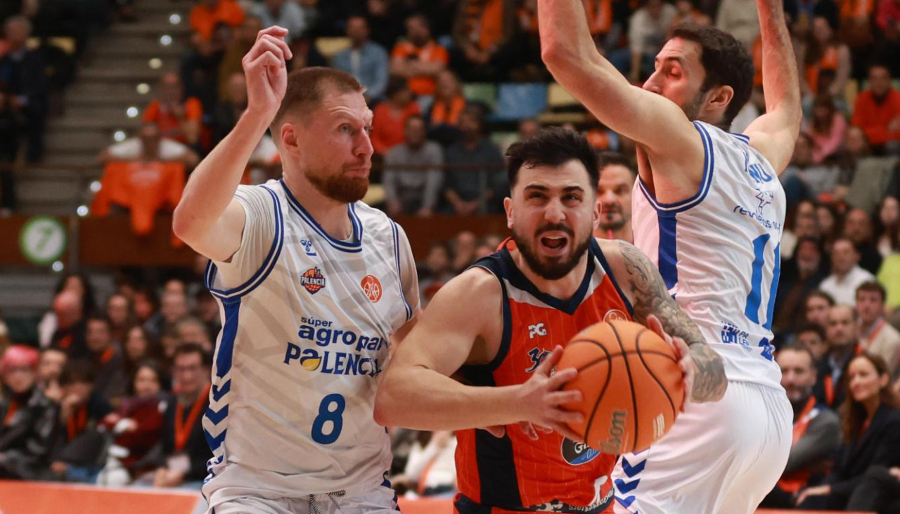 Dídac Cuevas entra a canasta entre los jugadores del Palencia Ingus Jakovics y Manu Rodríguez