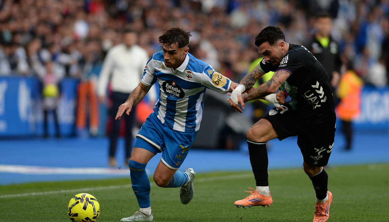 Alti, superando en carrera a Joaquín Fernández en el Deportivo-Málaga