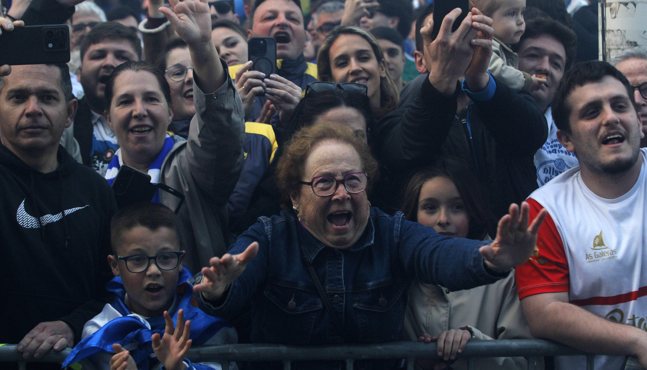 Una mujer entre los espectadores aplaude al equipo durante la llegada del Deportivo en la previa del encuentro ante el Málaga