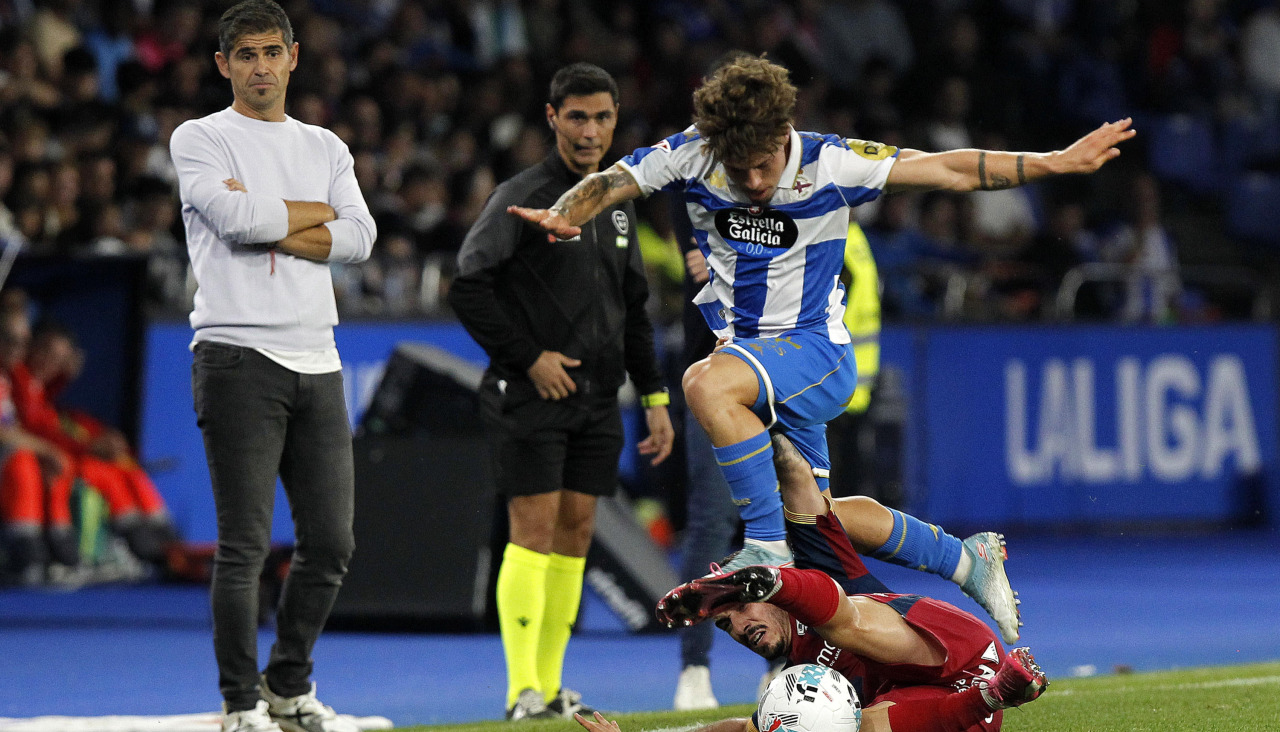 Mario Soriano sortea a un rival ante la mirada de Antonio Hidalgo en el Deportivo-Huesca