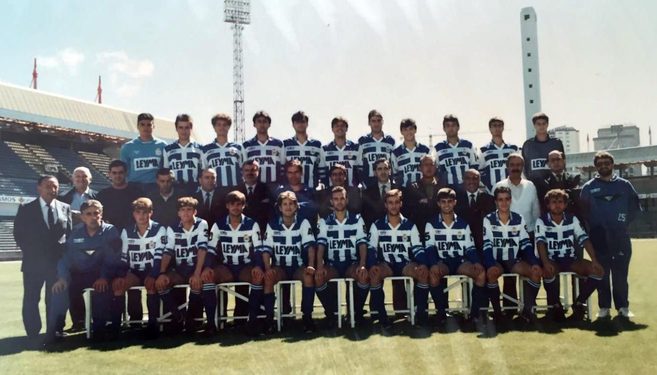 Plantilla del Fabril 1990-91 posando con el cuerpo técnico y la directiva deportivista en el estadio de Riazor