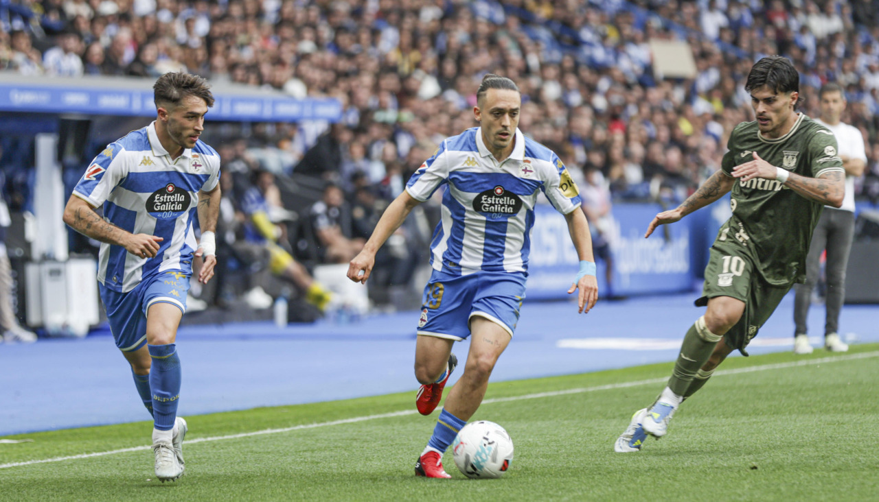 Luismi Cruz conduce el balón en el Deportivo-Leganés, acompañado por Altimira
