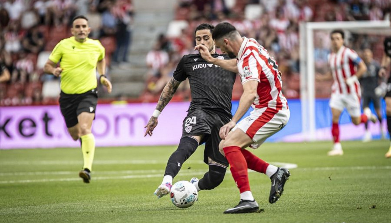 Pablo Vázquez, central del Sporting y autor de un gol, busca detener el avance de Miguel de la Fuente, jugador del Almería