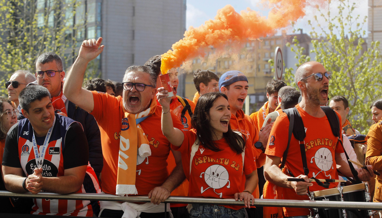 Aficionados del Básquet Coruña con botes de humo naranja durante el recibimiento al equipo el día del derbi contra el Obradoiro