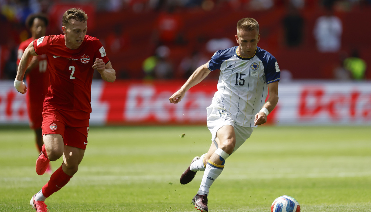 Alistair Johnston (i) de Canadá disputa el balón con Amar Memic de Bosnia en el partido del grupo B del Mundial en el estadio BMO Field de Toronto