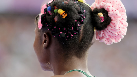 El colorido peinado de Prestina Oluchi Ochonogor de Nigeria mientras competía en el salto de longitud