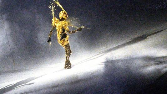 Un artista actúa como extraterrestre durante la ceremonia de clausura