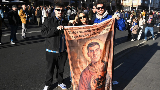 Dos aficionados posan junto a Lucía Dávila con una imagen de Diego Villares